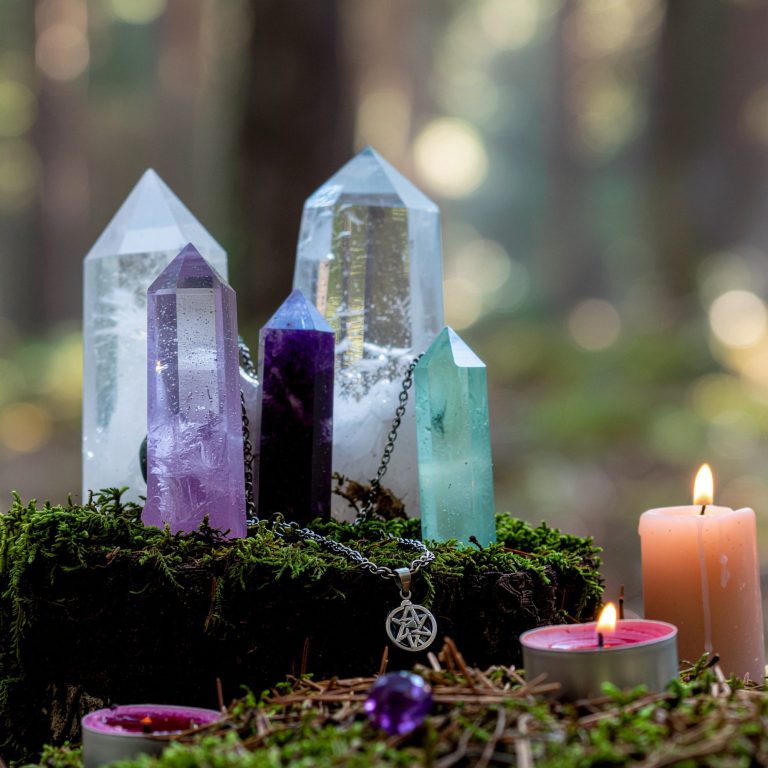 Faelorin - Wiccan Crystals and Candles on Altar Crystals atop moss with candles in a serene forest setting.